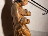 a wooden statue of a man with a hat and a sword
