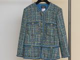 une veste en tweed bleu et vert suspendue à un cintre dans une pièce