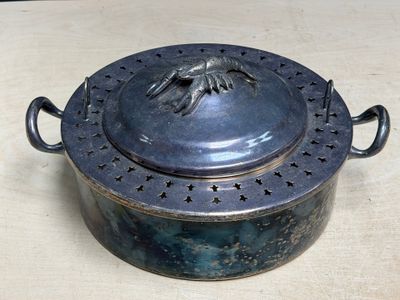 a large metal pot with a lid on a table