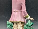 a figurine of a woman sitting on top of a tree stump