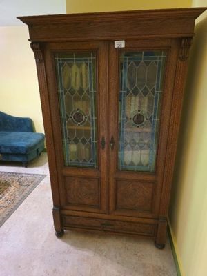 un meuble en bois avec des portes en verre dans le coin d'une pièce