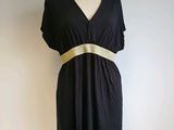 black dress with a gold belt on a mannequin stand