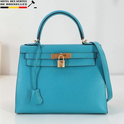 un sac à main bleu posé sur une table blanche