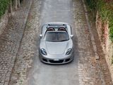 a silver sports car driving down a cobblestone road