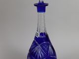 a blue glass bottle that has a design on it