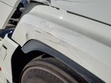 a white truck with a flat bed parked in a parking lot