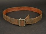 an old leather belt with a metal buckle on a black surface