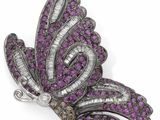 un gros plan sur une broche en forme de papillon violet et blanc