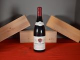 a bottle of wine sitting on a table next to a wooden box