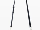 a black purse with a long strap on a white background