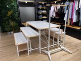 une table blanche avec deux bancs devant