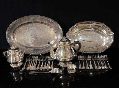 un plateau en argent et des couverts en argent posés sur une table noire