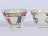 three cups with designs on them are sitting next to each other