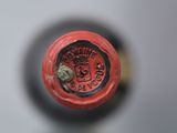 a close up of a red wine bottle with a crown on it