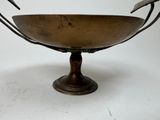 a metal bowl with a bird on it on a stand