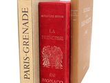 trois livres sont empilés sur une surface blanche