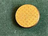 une petite pièce d'or posée sur une surface verte