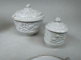 a white table with a plate and a bowl on it