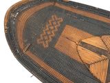 an old woven basket with a design on it