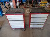 pair of red and white tool boxes with wheels in a garage