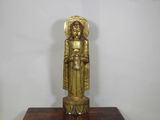 statue en laiton représentant une femme tenant un bébé dans ses bras, posée sur un socle en bois