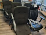 Plusieurs chaises de bureau sont alignées en rang dans une pièce