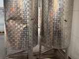 deux grandes cuves en acier inoxydable posées sur une palette en bois