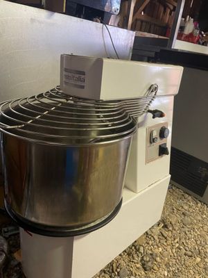 a mixer that is sitting on the ground next to a counter
