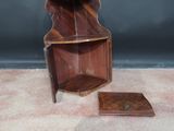 a small wooden shelf with a mirror on top of it