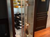 une vitrine contenant des bouteilles de vin, posée sur un plancher en bois