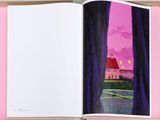an open book with a picture of a house in the background
