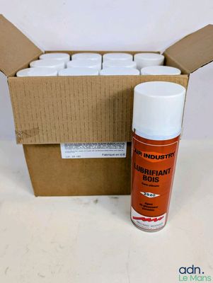 une photo montrant un pot de peinture en spray blanche à côté d'un carton