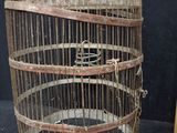 a bird in a cage sitting on a black surface
