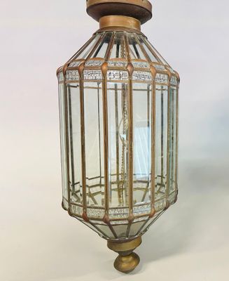 an antique brass and glass lantern hanging from the ceiling
