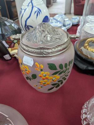 une table sur laquelle se trouvent un vase et d'autres objets en verre
