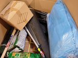 a cardboard box filled with cleaning supplies and a broom
