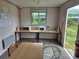 une pièce avec une table, des chaises et un micro-ondes posé dessus