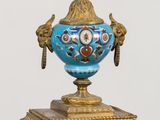 a blue and gold clock with a bird on top of it