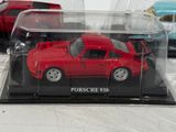 a red toy car in a clear case on a table