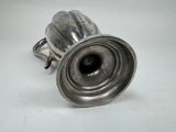 an antique silver plated metal object on a white surface