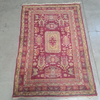 un tapis rouge et jaune posé sur un sol en béton