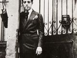 une photo en noir et blanc d'un homme debout devant un portail