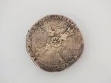 an old silver coin with a bird on it on a white surface