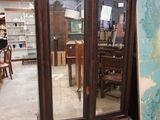 une grande armoire en bois surmontée d'un miroir