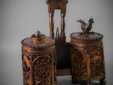 two wooden boxes with carvings on them and a bird sitting on top of them