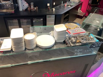 many plates and cups on the counter of a restaurant