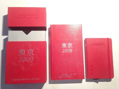 trois livres rouges posés les uns à côté des autres sur une table