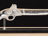a clear glass gun on a black base on a wooden table