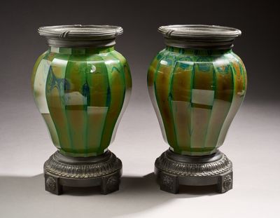 deux vases verts posés l'un à côté de l'autre sur une table