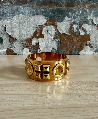 a close up of a gold ring on a wooden table